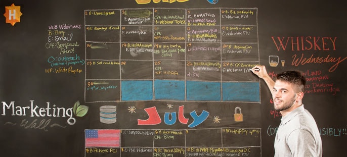 HOSTING employee in front of marketing wall