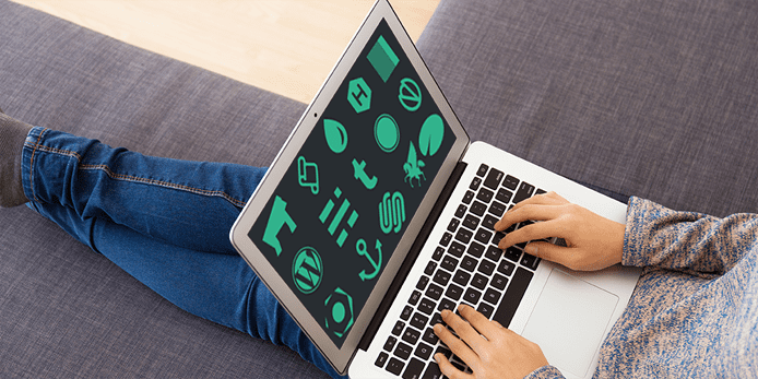Photo of a person on a laptop with website builder logos on its screen