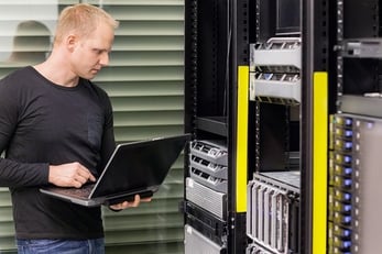 Stock photo of datacenter admin monitoring servers