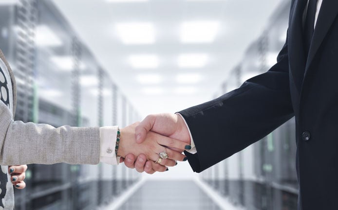 Photo of business people shaking hands in a datacenter Photo of business people shaking hands in a datacenter