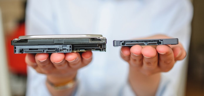 Person holding a hard disk drive and solid-state drive