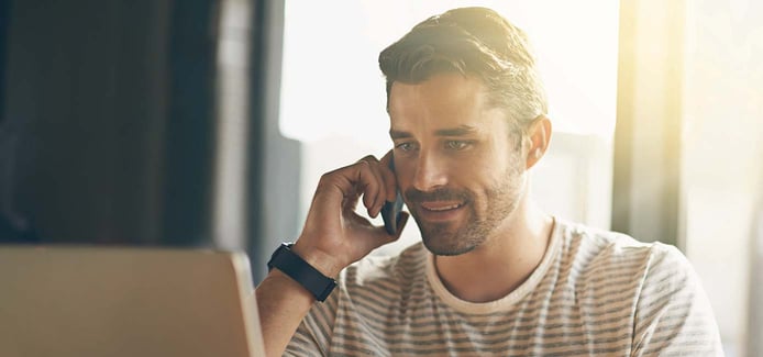 Image of a man in front of a computer calling customer support Image of a man in front of a computer calling customer support