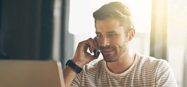 Image of a man in front of a computer calling customer support Image of a man in front of a computer calling customer support