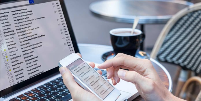 Image of woman checking email on her laptop and phone Image of woman checking email on her laptop and phone