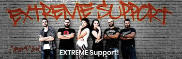 Photo of support staff against a wall with graffiti reading "EXTREME SUPPORT"