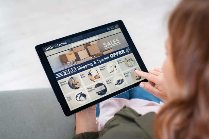 Back view of woman doing shopping online on website with digital tablet at home. Top view of lady on relaxing sofa. Rear view of girl hand touching screen while selecting product on e-commerce portal. Back view of woman doing shopping online on website with digital tablet at home. Top view of lady on relaxing sofa. Rear view of girl hand touching screen while selecting product on e-commerce portal.