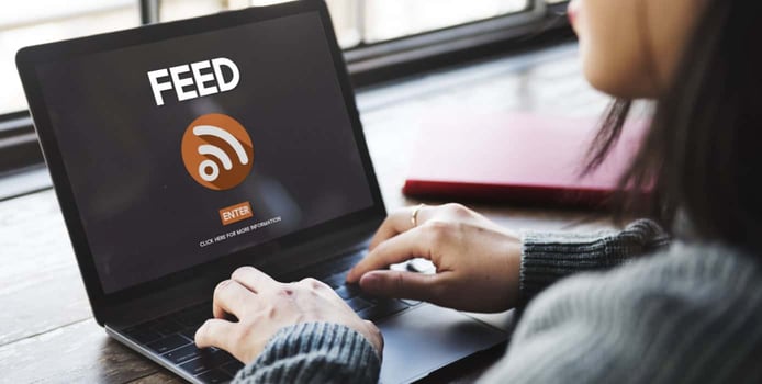 Woman on a laptop with the text RSS feed