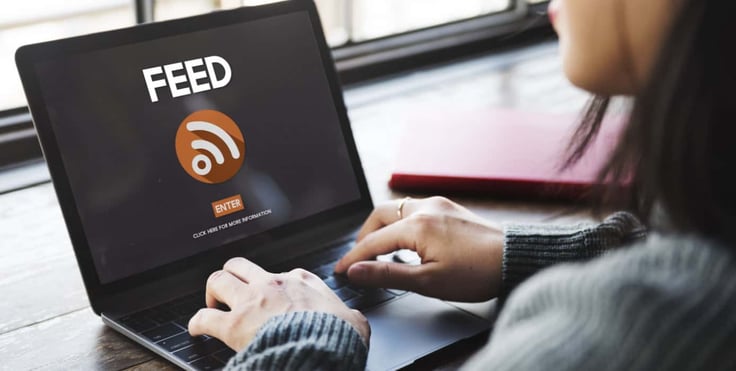 Woman on a laptop with the text RSS feed