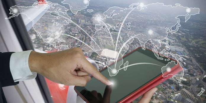 Hand touching a smart pad with global map Hand touching a smart pad with global map