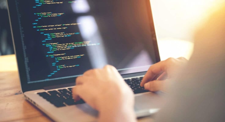 Person coding a website from scratch on a laptop Person coding a website from scratch on a laptop