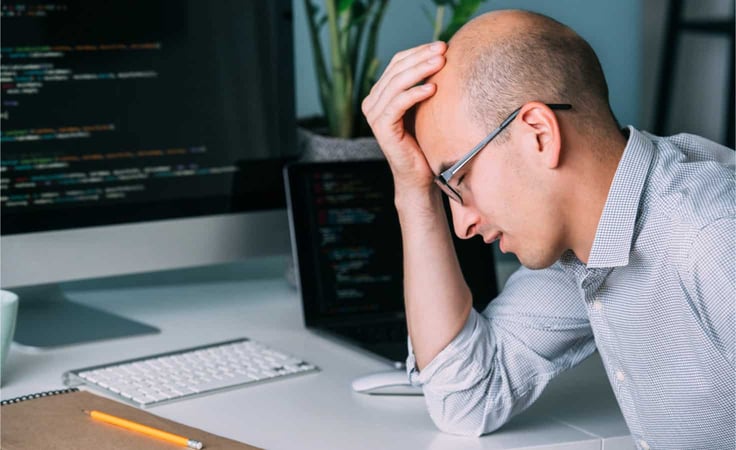 A frustrated software developer who can't figure out what's wrong with his code. A frustrated software developer who can't figure out what's wrong with his code.