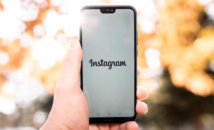 A person holding a smartphone on the Instagram app. A person holding a smartphone on the Instagram app.