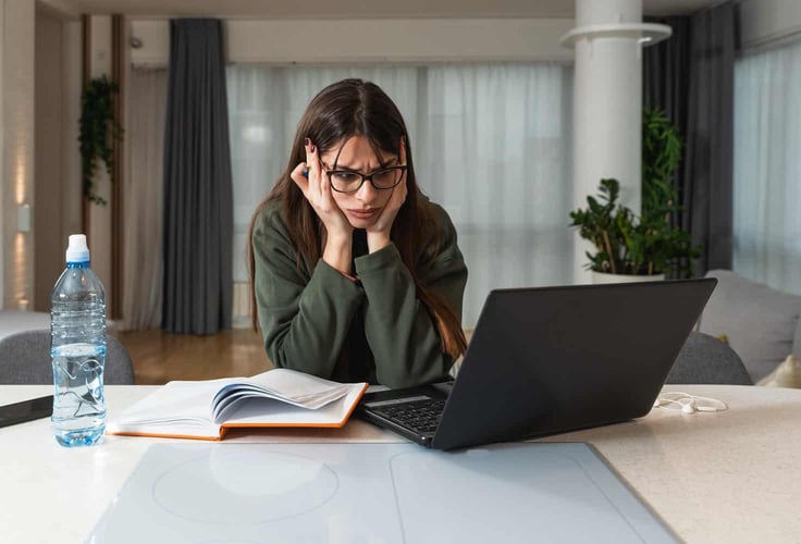 A woman sitting at her laptop, clearly frustrated about loading times. A woman sitting at her laptop, clearly frustrated about loading times.