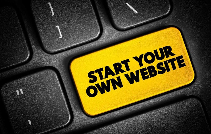A close up of a keyboard with a bright yellow button that says 'Start your own website.' A close up of a keyboard with a bright yellow button that says 'Start your own website.'