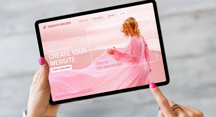 Person holding a tablet with a website builder Person holding a tablet with a website builder