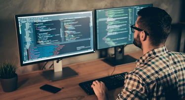 A man at a computer using code