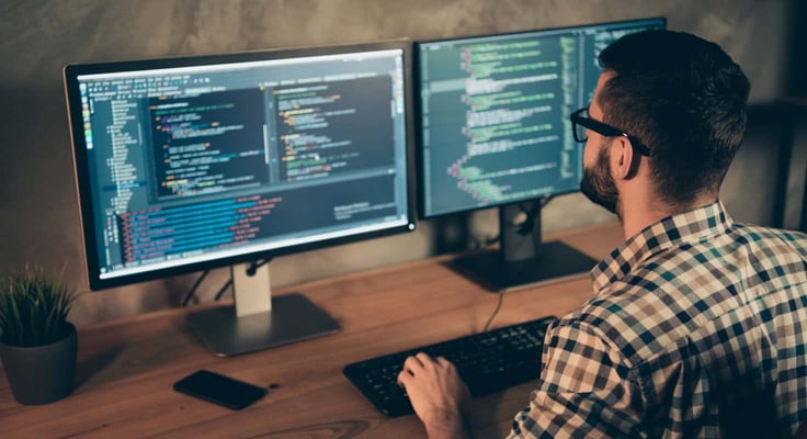 A man at a computer using code A man at a computer using code