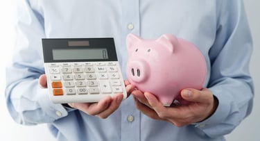 A Man Holding a Calculator and Piggy Bank