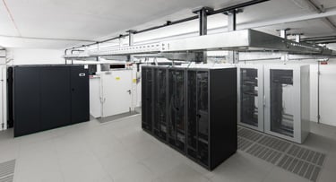 Wide angle view of small air conditioned computer room with racks and cable trays