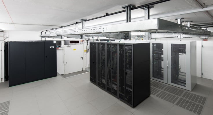 Wide angle view of small air conditioned computer room with racks and cable trays