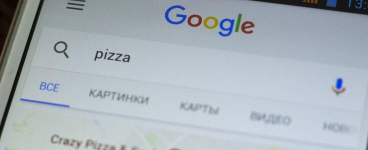 Generic smartphone screen close up with google search application. Macro shot of search query for pizza delivery. Abstract internet services background