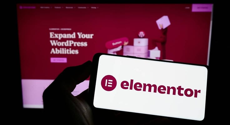 Person holding mobile phone with logo of Israeli software company Elementor Ltd. on screen in front of business web page. Focus on phone display. Unmodified photo. Person holding mobile phone with logo of Israeli software company Elementor Ltd. on screen in front of business web page. Focus on phone display. Unmodified photo.