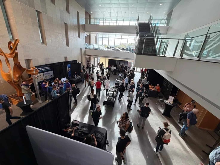 A photo of WordCamp Canada 2025, showing people walking around a busy hall venue A photo of WordCamp Canada 2025, showing people walking around a busy hall venue