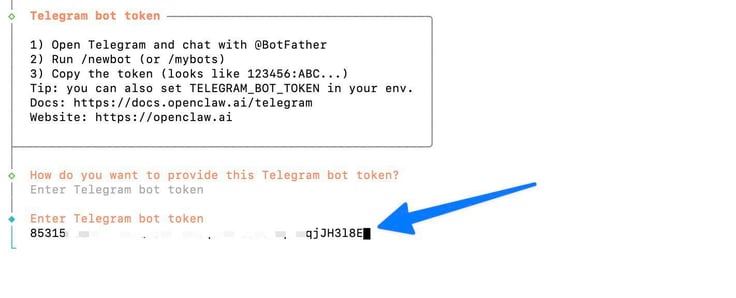 OpenClaw configure terminal showing the Telegram bot token setup instructions panel with steps to chat with @BotFather and run /newbot, followed by the Enter Telegram bot token prompt with a partially redacted bot token being entered, highlighted by a blue arrow OpenClaw configure terminal showing the Telegram bot token setup instructions panel with steps to chat with @BotFather and run /newbot, followed by the Enter Telegram bot token prompt with a partially redacted bot token being entered, highlighted by a blue arrow