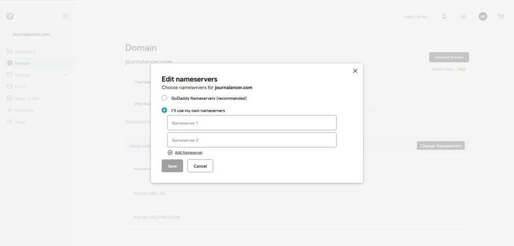 GoDaddy Edit Nameservers modal dialog for journalancer.com showing two nameserver options â GoDaddy Nameservers recommended and I'll use my own nameservers selected with a teal radio button â with empty Nameserver 1 and Nameserver 2 input fields, an Add Nameserver link, and Save and Cancel buttons