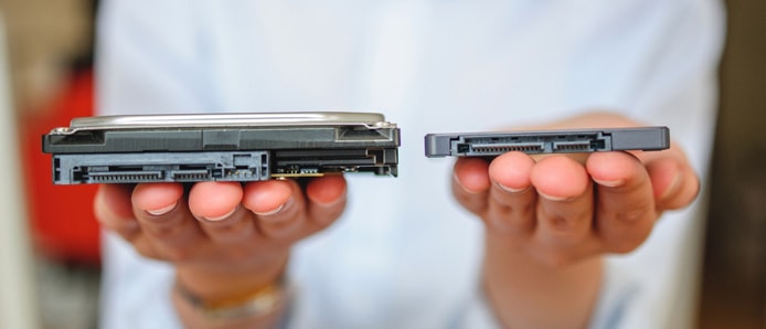 Person holding an SSD and HDD Person holding an SSD and HDD