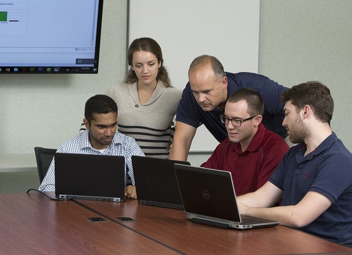 Photo of people collaborating around computers Photo of people collaborating around computers