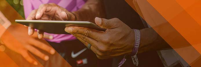 Image of hands holding an iPad on the sideline Image of hands holding an iPad on the sideline