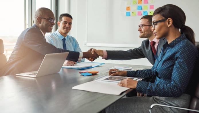 Photo of people shaking hands at a meeting Photo of people shaking hands at a meeting