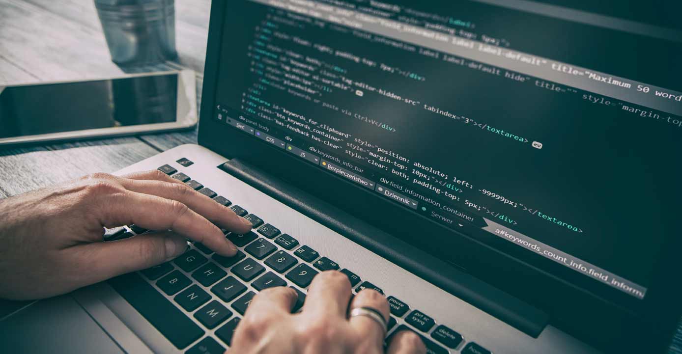 Image of hands typing code on a laptop Image of hands typing code on a laptop