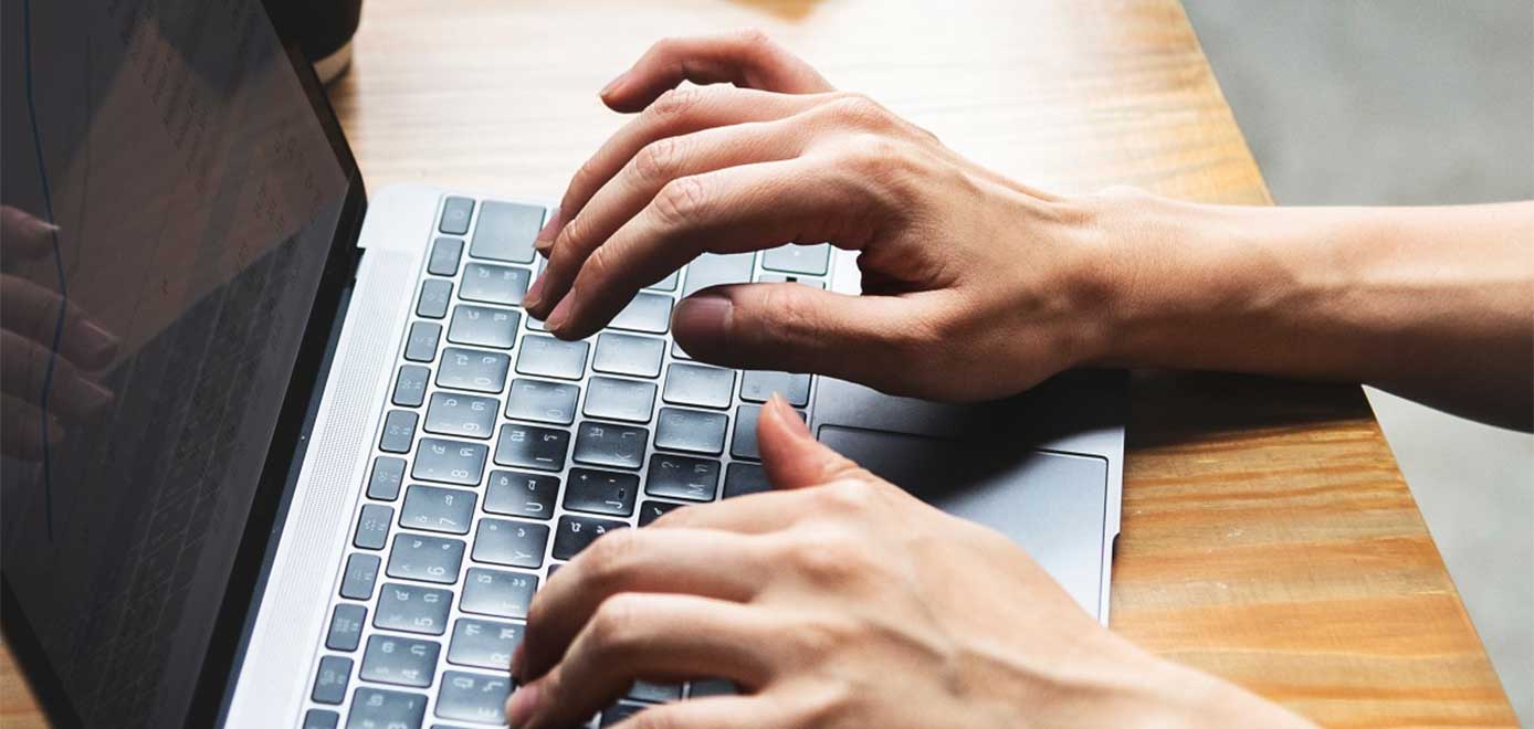 Image of hands typing on a laptop Image of hands typing on a laptop